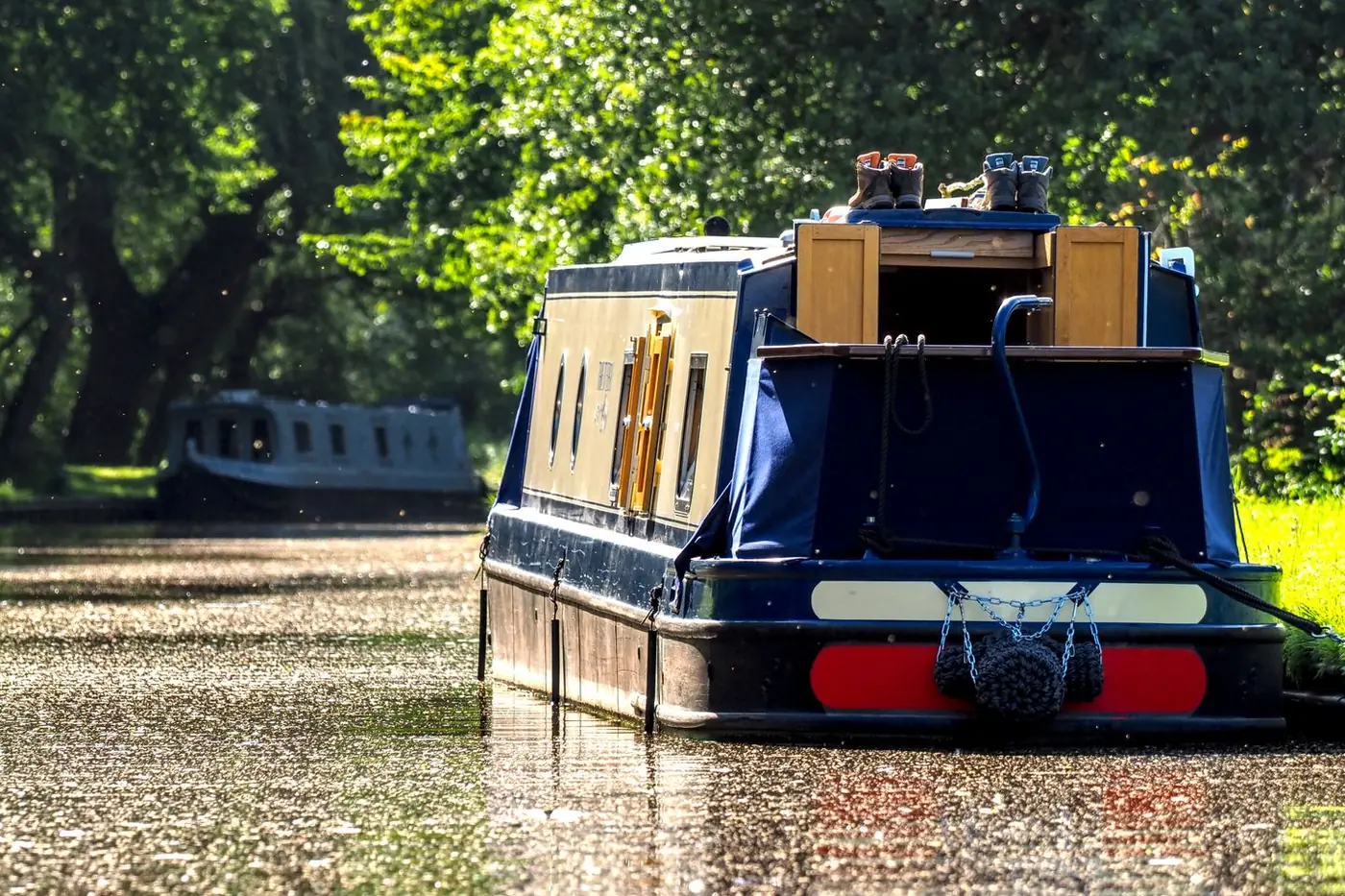 Navy blue narrowboat on a sunlit canal