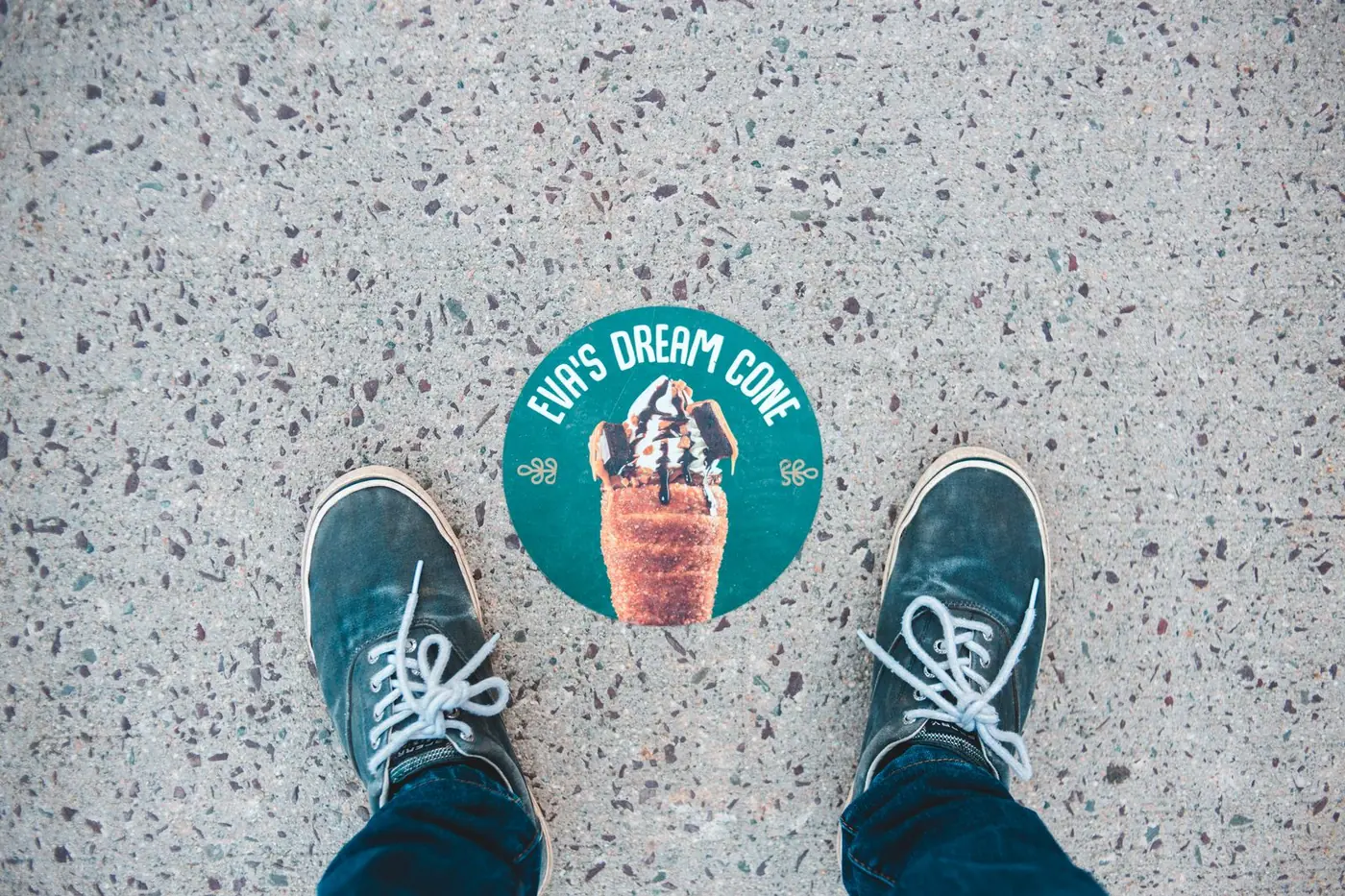 Printed floor sticker for an ice cream shop between a pair of trainers