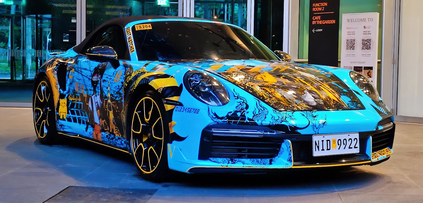 Sports car wearing a bold cyan and yellow colourful graphic vinyl wrap design