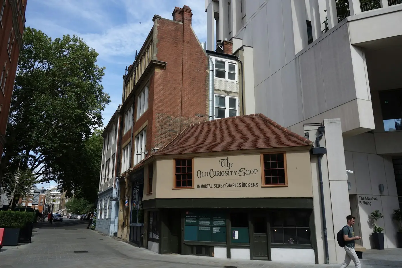 Painted fascia sign on The Old Curiosity Shop, a timber-framed London building with a tiled roof