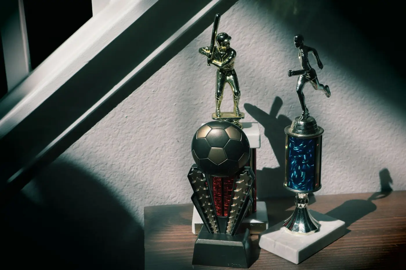 Football and baseball trophies on a shelf