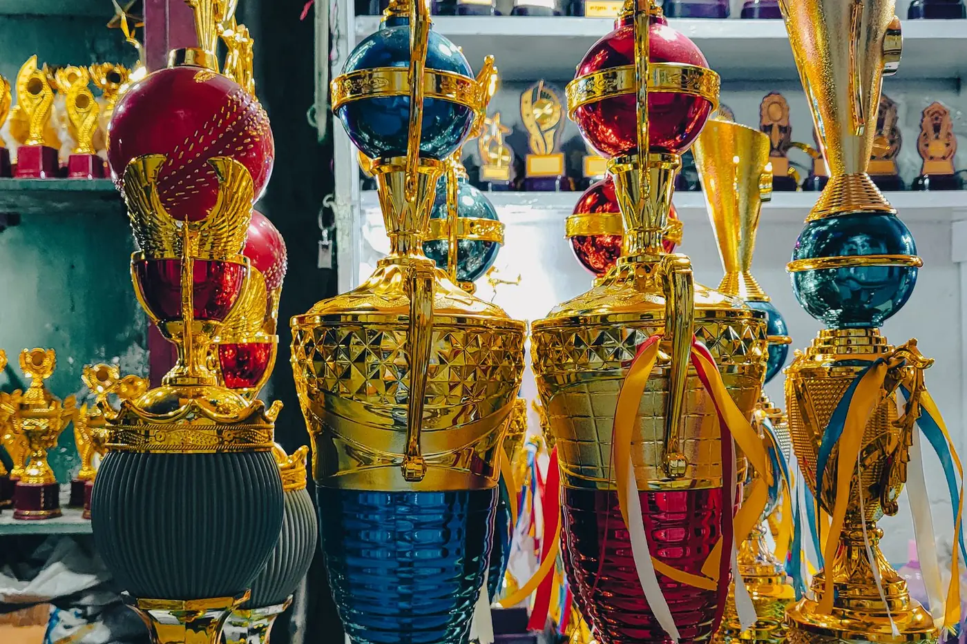 A shop display of tall gold trophies