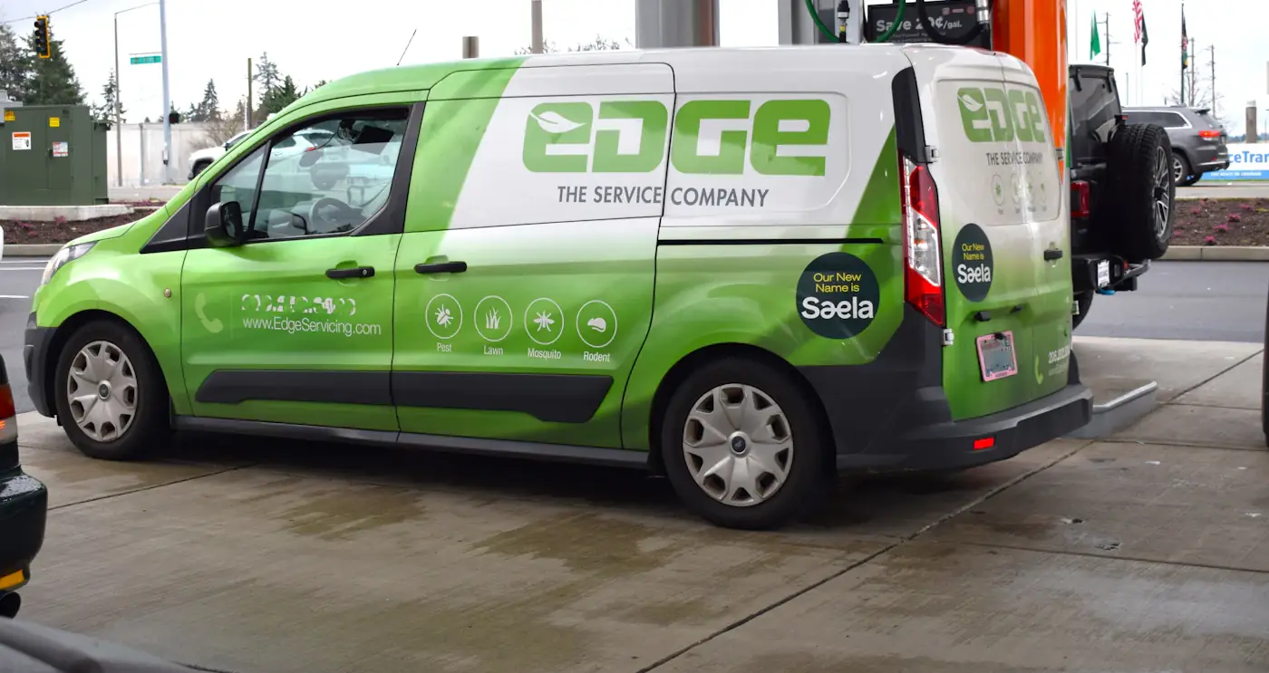 Green and white small van with full commercial livery, logo, website and service icons