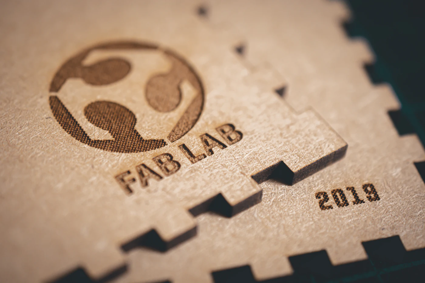 Close-up of a laser engraved logo and date on a finger-jointed wooden panel